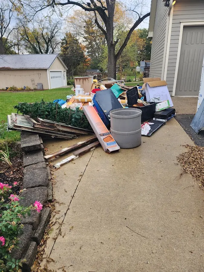 Dumpster being loaded with debris for 12 Yard Dumpster Rental in Farmers Branch